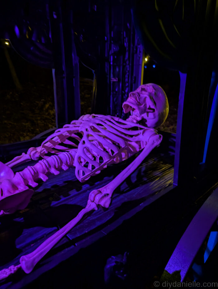 Outdoor Halloween trail at night with lit props and animatronics creating a spooky atmosphere.