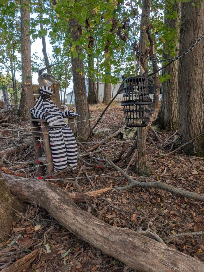 DIY Halloween electric chair display set outdoors, showing some wear from being left in the woods.