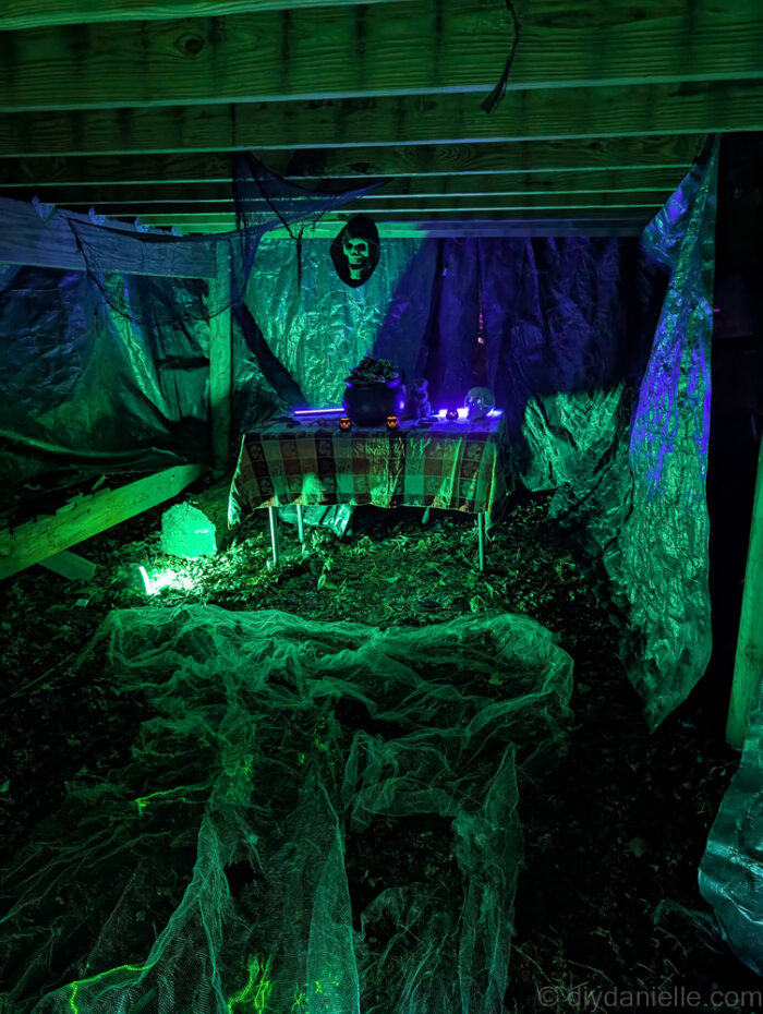Outdoor Halloween trail at night with lit props and animatronics creating a spooky atmosphere.