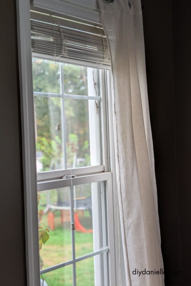 Linen curtains hanging on the sliding glass door and windows in a newly renovated living room.
