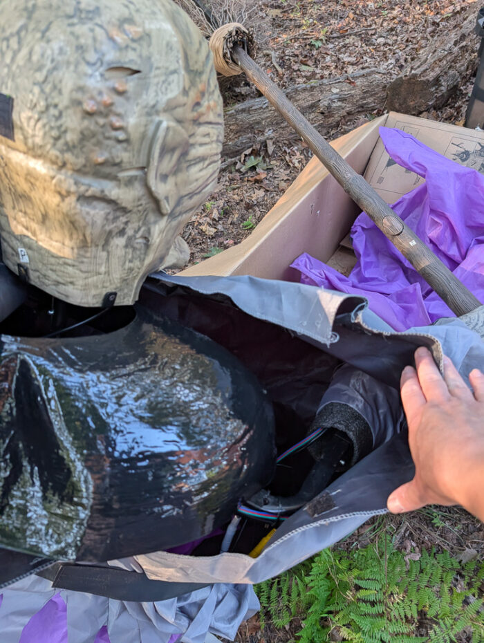 Detail of adjusting the back of the witch’s dress to reach and connect parts of the 12 ft. Hovering Witch Halloween decoration.