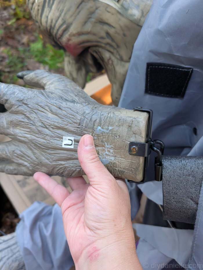 Hovering Witch Halloween decoration showing the opposite arm locked into place with hook-and-loop straps securing the dress sleeves.