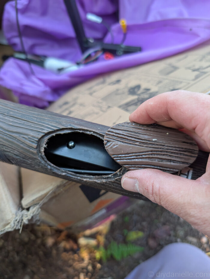 Close-up of the 12 ft. Hovering Witch Halloween decoration with the hand placed over the support bar for setup.