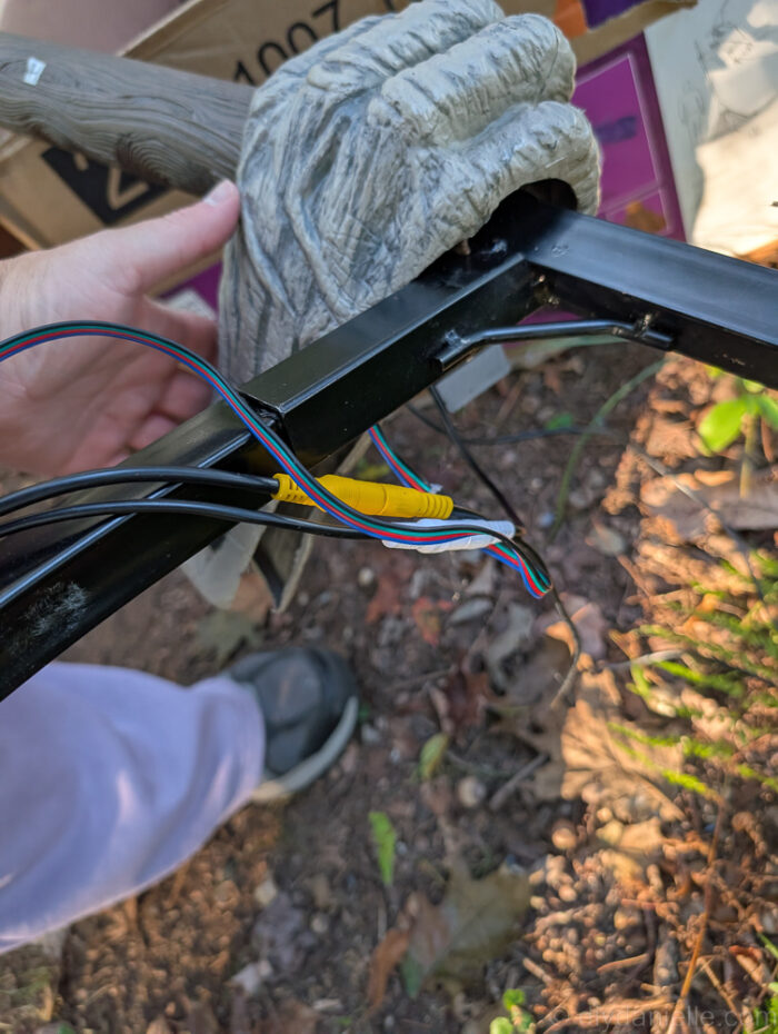 Hovering Witch Halloween decoration showing the witch’s hand sliding over the support bar for proper placement.
