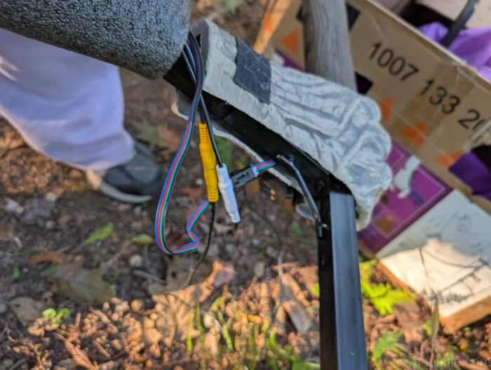 Detail of the 12 ft. Hovering Witch Halloween decoration with the oval faux wood piece reattached as the final step.
