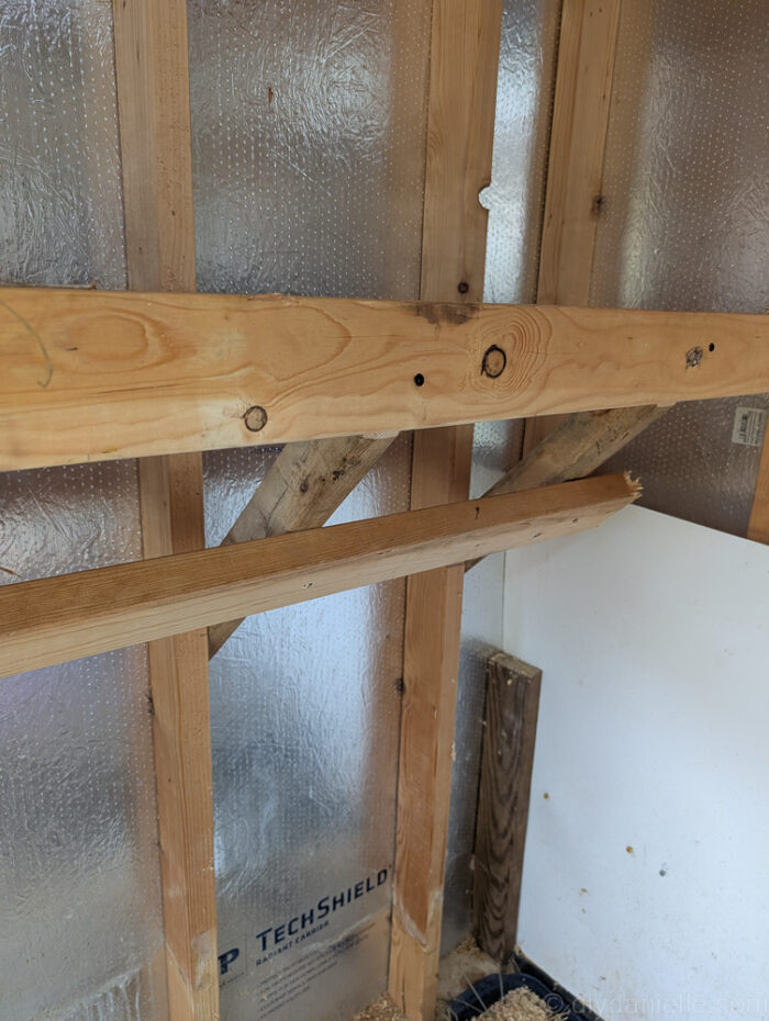 Middle 2x4 being attached to 2x2 vertical supports on a wall mounted hay feeder for stability.