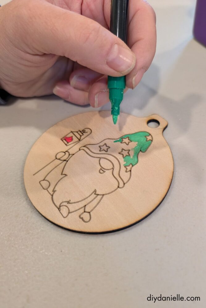 DIY ornament being coated with a clear sealer after painting, showing how to protect and finish handmade holiday decorations.