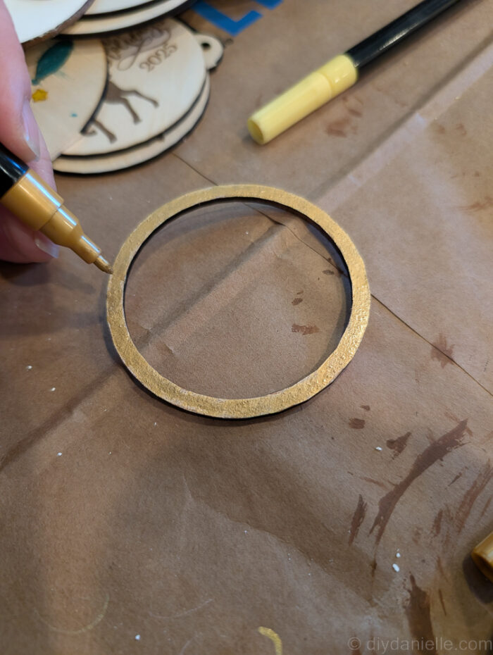 Separate layers of a wooden Christmas ornament being painted individually for a neat, professional-looking finish.