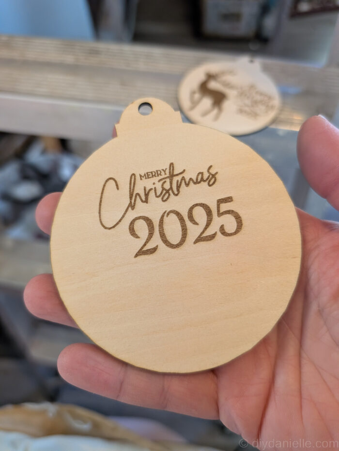 Two pieces of wooden Christmas ornament&mdash;base layer and top layer&mdash;ready to be glued together for a DIY two-layer ornament project.