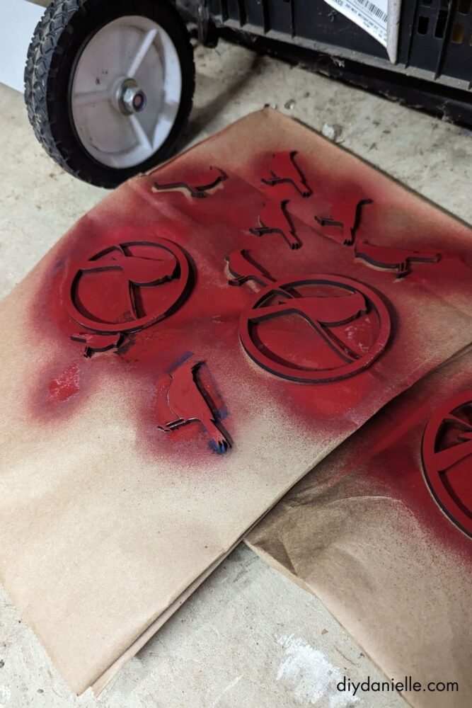 Separate layers of a wooden Christmas ornament being painted individually for a neat, professional-looking finish.