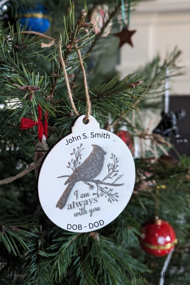 White-painted wooden cardinal ornament with engraved design, showing a farmhouse-style holiday decoration.