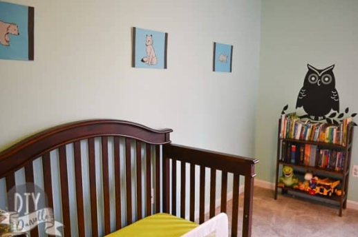 Nursery textiles and blackout curtains styled with Tame Teal SW6757 walls, coordinating crib bedding, rug, and soft fabrics.