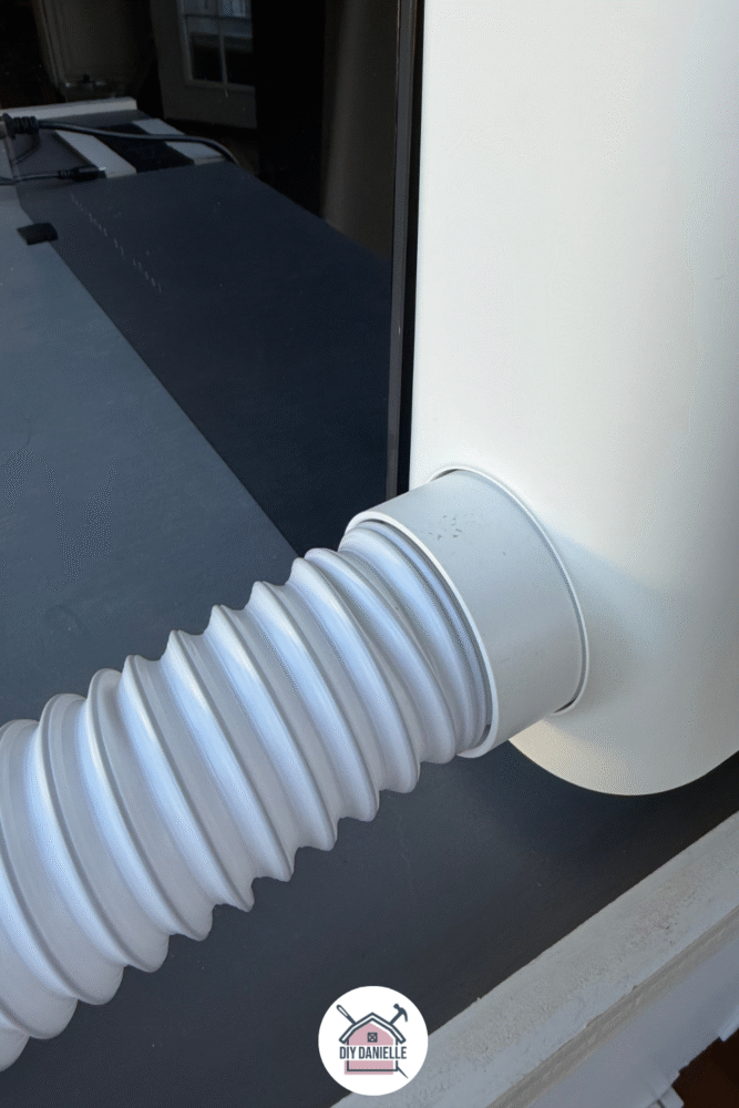 Photo of the back of the O1 Dual Head Omni UV printer showing a close up shot of where the white tubing leaves the machine to allow you to vent the machine out a window.